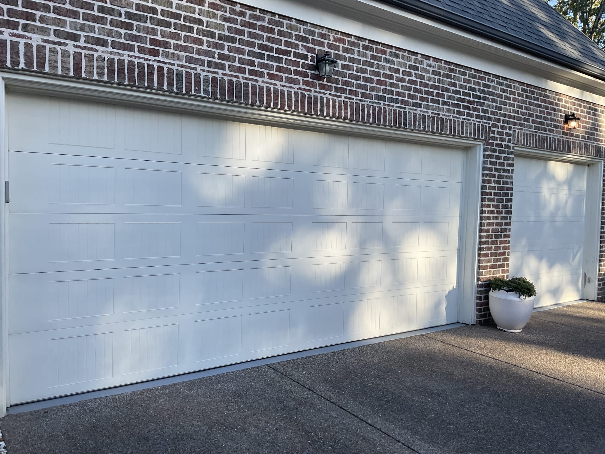 Finished white carriage-style garage doors installed by Lift Doctors in Greater Memphis